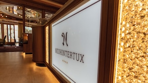 Et indrammet skilt med navnet "NEUHINTERTUX" og tre stjerner, der angiver en bedømmelse.