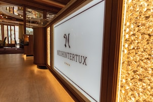 A framed sign with the name "NEUHINTERTUX" and three stars, indicating a rating.