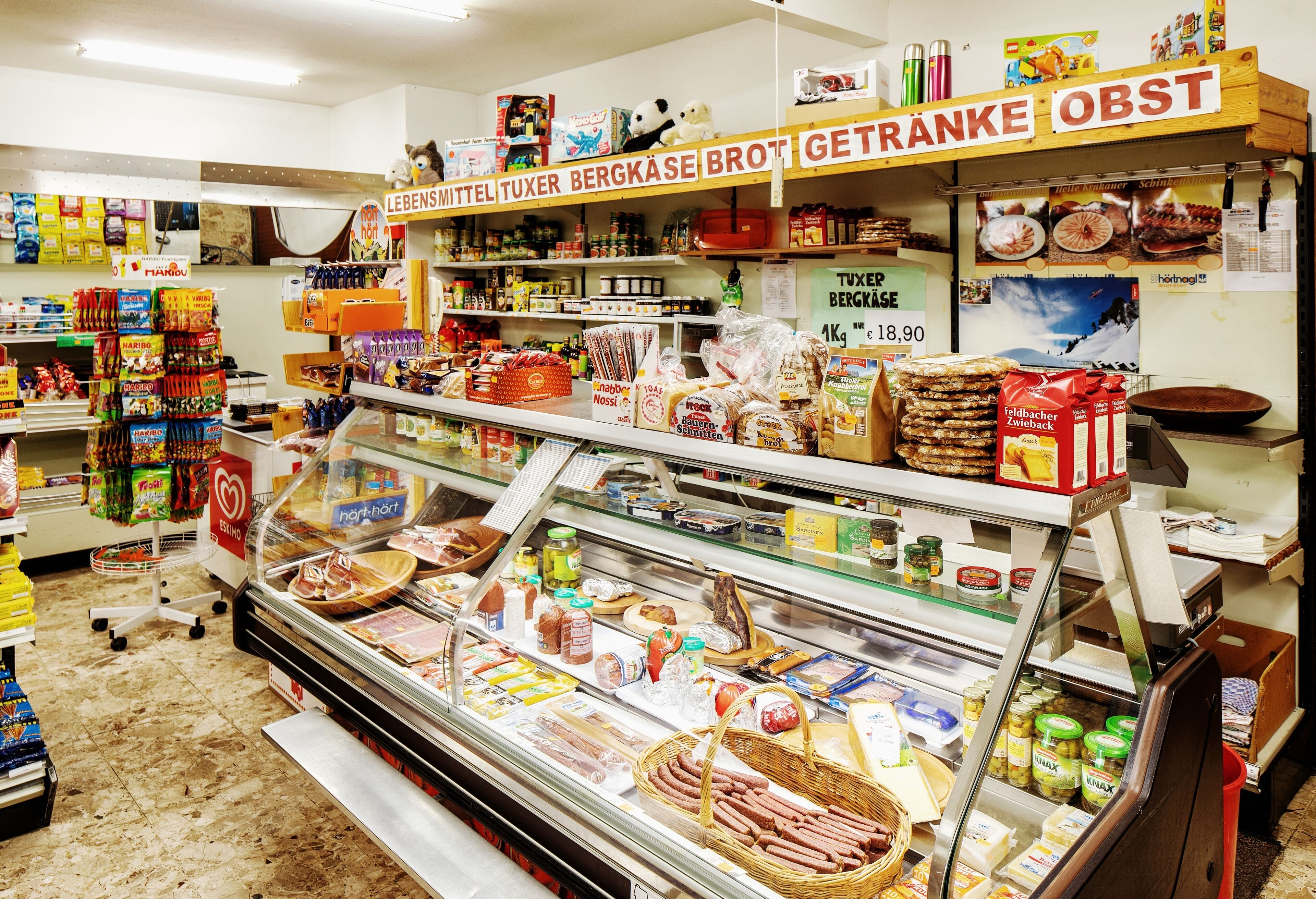 A grocery store with a deli counter displaying various meats and cheeses.