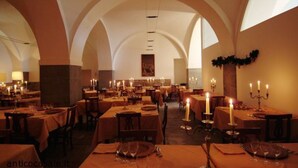 Un restaurante con varias mesas, velas y un ambiente cálido.