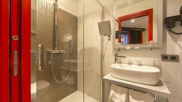 Een moderne badkamer met een douchekabinet van glas, een witte wastafel en een spiegel met rode rand.