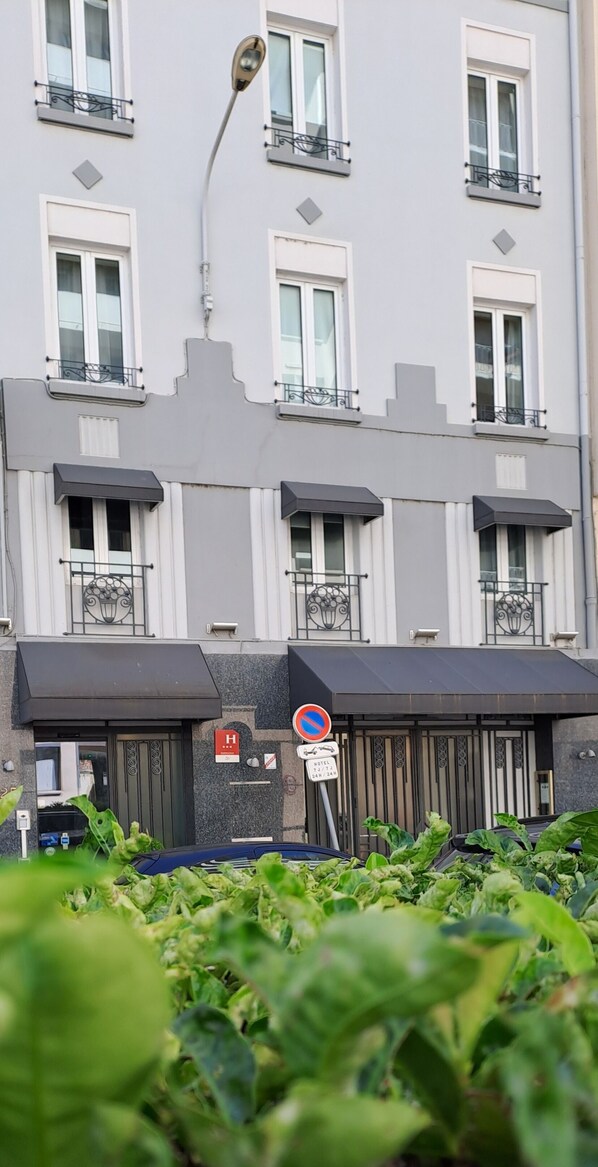 A hotel facade with multiple windows, a no parking sign, and a hotel sign. - Hôtel Boutique Richelieu Lyon Gare Part Dieu (Lyon)