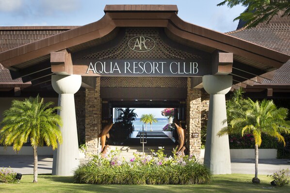 The entrance to Aqua Resort Club with a view of the ocean and palm trees. - Aqua Resort Club Saipan (Saipan)