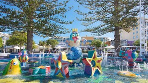 A water park with various colorful water features and a large inflatable character.