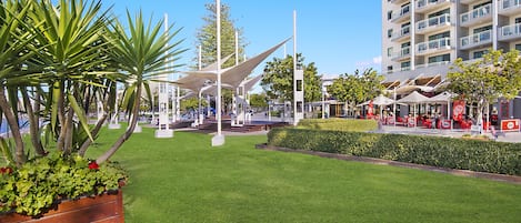 A modern hotel with a rooftop terrace, outdoor seating area, and well-maintained landscaping.