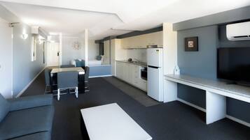A compact living space with a kitchenette, a dining area, and a seating area.