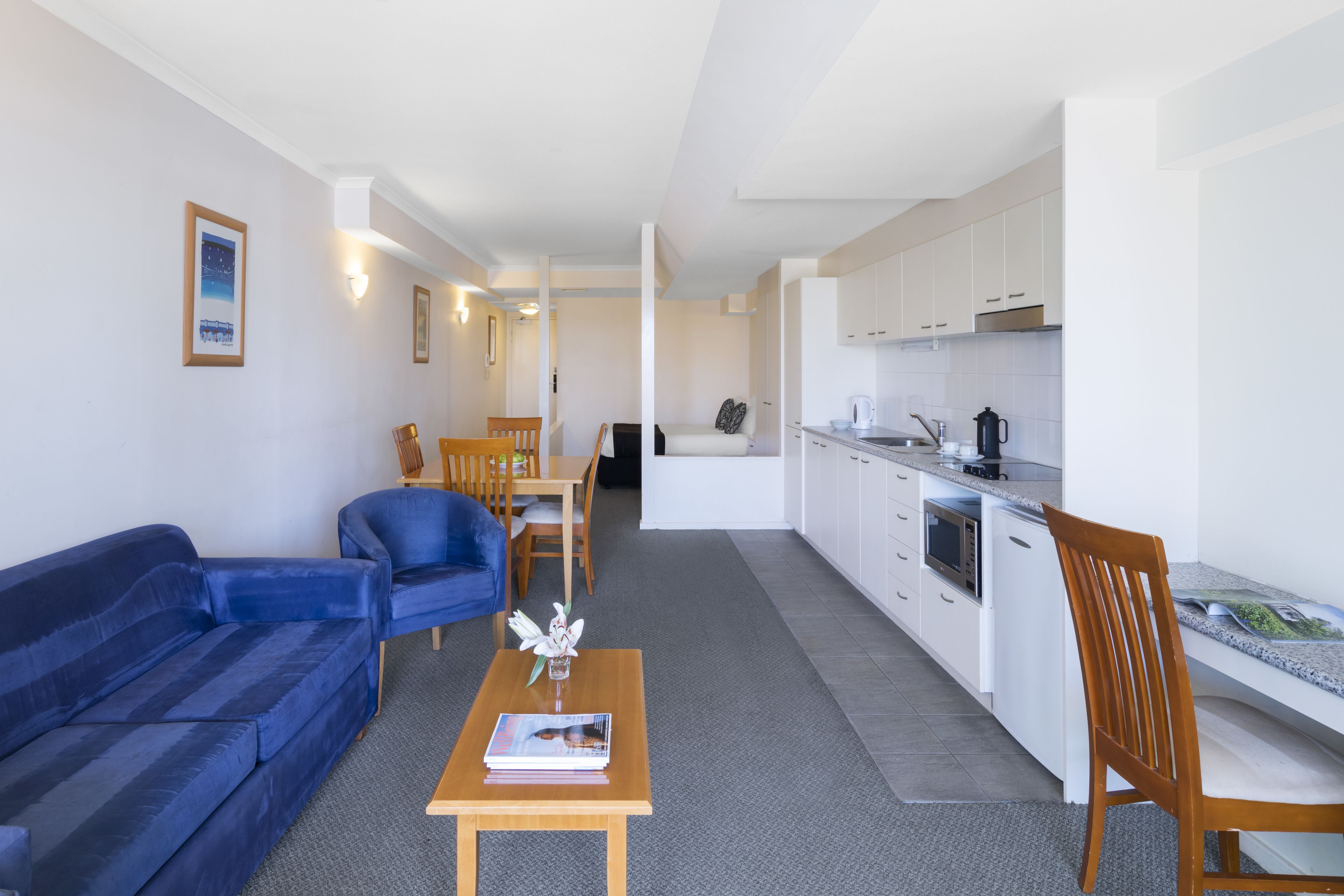 A compact living space with a sofa, a dining table, and a kitchenette.