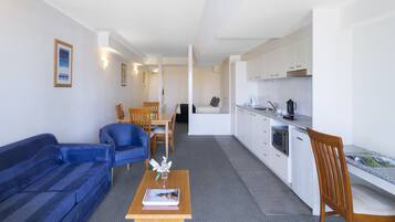 Un espace de vie compact comprenant un canapé, une table à manger et une kitchenette.