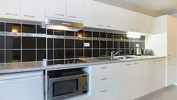 Estudio Deluxe | Cocineta privada | Refrigerador, microondas, parrilla de estufa y cafetera y tetera