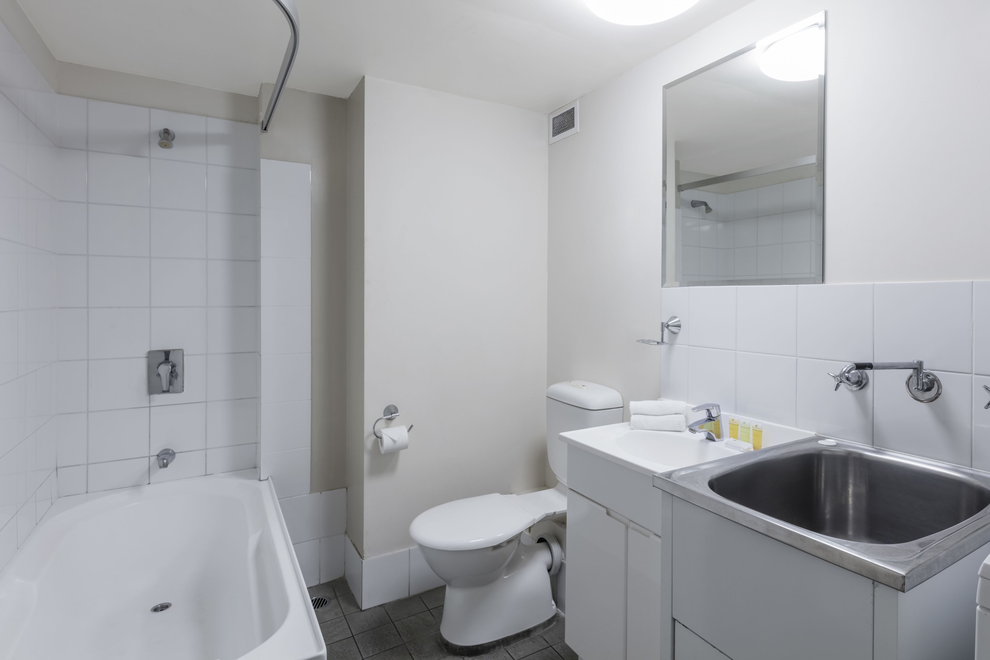 Un baño moderno con bañera, inodoro, lavabo y espejo.