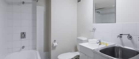 Un baño moderno con bañera, inodoro, lavabo y espejo.