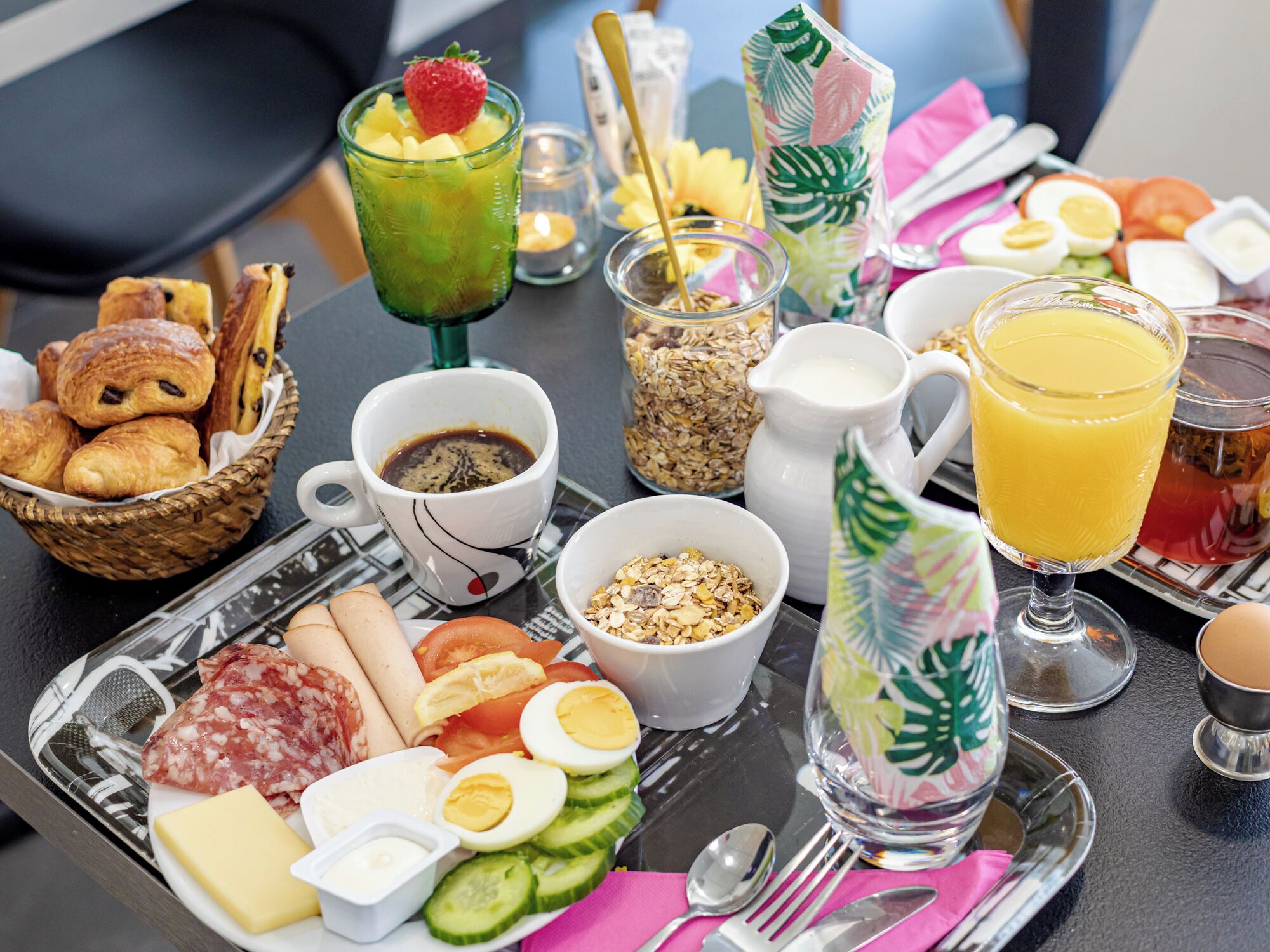 A breakfast tray with croissants, eggs, cheese, and ham.