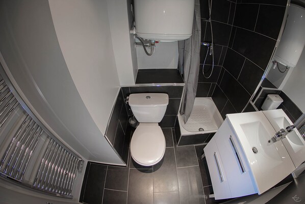 A modern bathroom with a toilet, bidet, and sink.