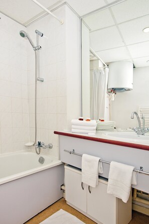 Un bagno moderno con vasca, doccia e lavandino.