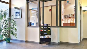A reception area with a bulletin board displaying various items. - Séjours & Affaires Rouen Normandie (Sotteville-les-Rouen)