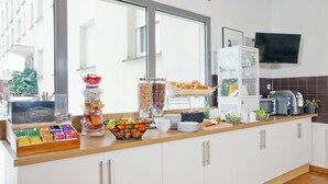 A breakfast bar with various food items and a coffee machine. - Séjours & Affaires Rouen Normandie (Sotteville-les-Rouen)