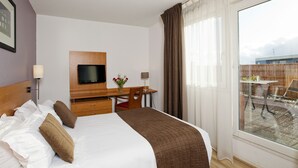 A hotel room with a bed, a desk, a television, and a view of the outdoors. - Séjours & Affaires Rouen Normandie (Sotteville-les-Rouen)