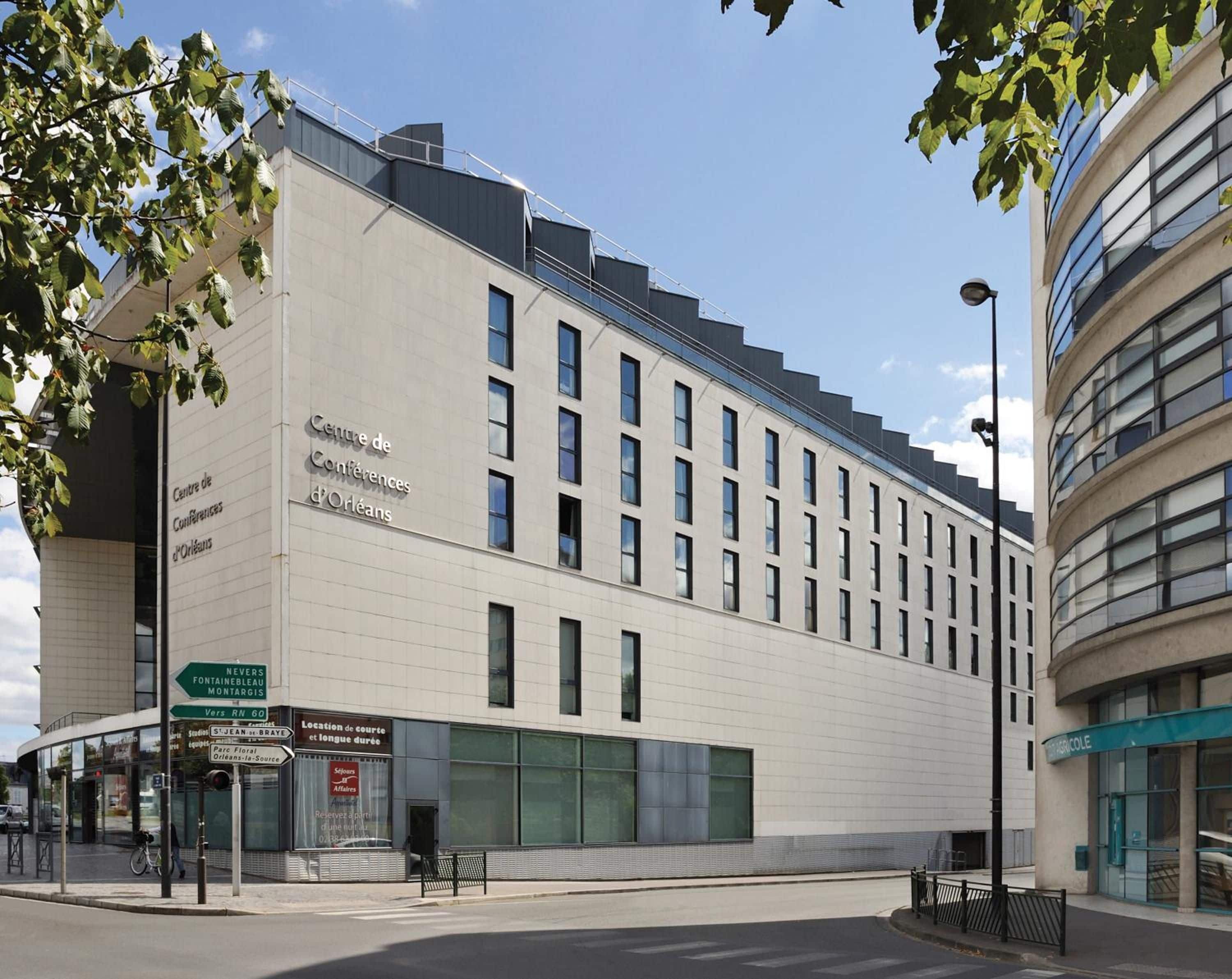 Un bâtiment moderne avec une enseigne indiquant « Centre de conférences d’Orléans ».