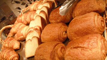A basket filled with various types of bread, including croissants and baguettes.