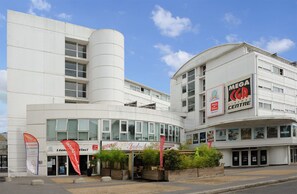 A modern building with a cinema center, restaurant, and a large cylindrical structure.