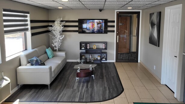 A modern living room with a sofa, coffee table, and decorative plants. - Horizon Inn Motel (Lincoln)