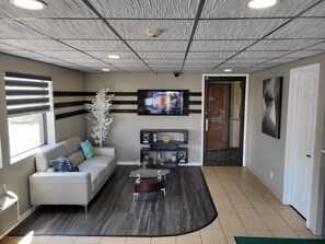 A modern living room with a sofa, coffee table, and decorative plants. - Horizon Inn Motel (Lincoln)