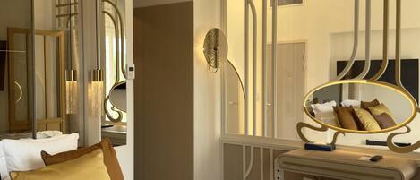 A modern hotel room with a large bed, a vanity with a mirror, and a desk.