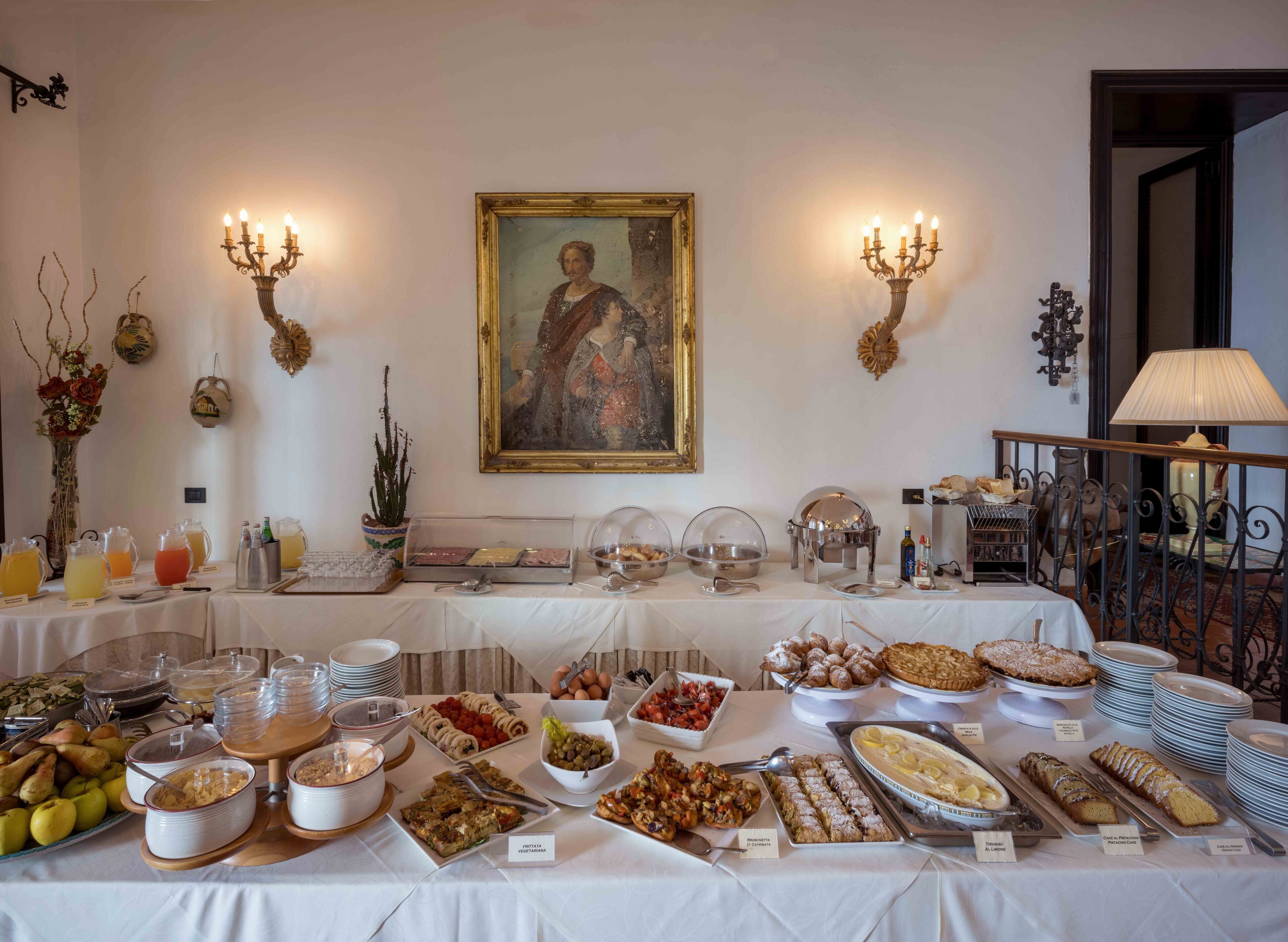 Una mesa de bufé con diversos alimentos y un cuadro en la pared.