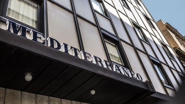 Fachada de edificio con el nombre 'MEDITERRANEO' en relieve.