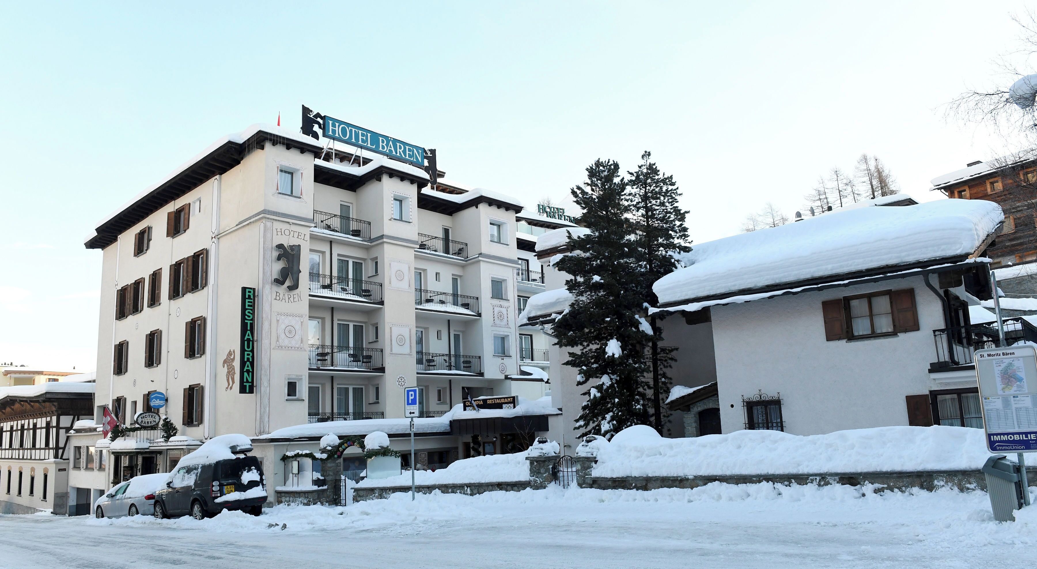 A hotel with a sign reading 'HOTEL BAREN,' a restaurant sign, and a map sign.