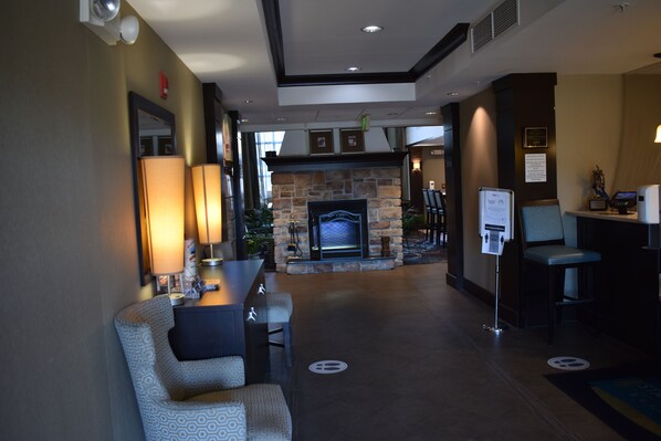 A lobby with a stone fireplace, seating area, and a reception desk. - Staybridge Suites Cranbury by IHG (Cranbury)