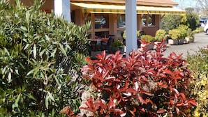 Een hotel genaamd 'Kyriad' met een overdekt terras en plantenpotten.