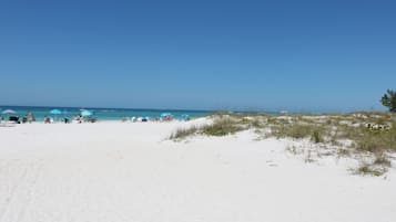 Perto da praia, areia branca, espreguiçadeiras, toalhas de praia