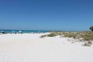 Una playa cerca, arena blanca, sillas reclinables de playa