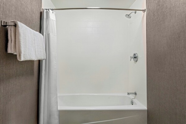 Un baño con ducha, bañera y toallero.