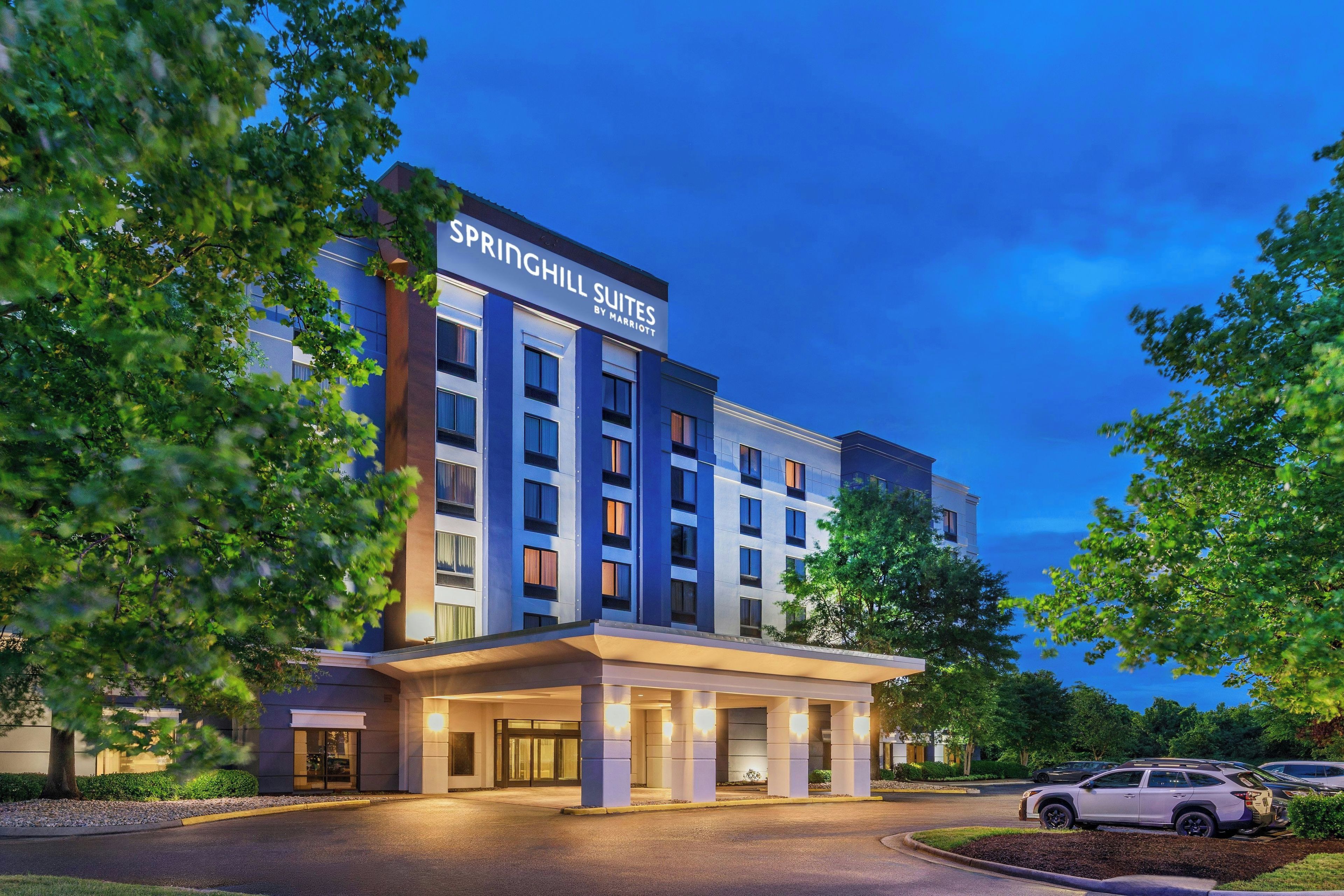 Un hotel de varios pisos con una señalización destacada que dice 'SPRINGHILL SUITES BY MARRIOTT' en la parte superior.