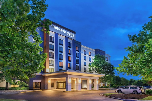 Un hotel de varios pisos con una señalización destacada que dice 'SPRINGHILL SUITES BY MARRIOTT' en la parte superior.