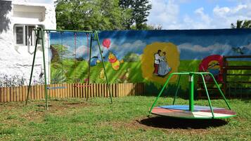 Children can play on the swing set and merry-go-round in this outdoor play area.