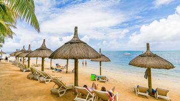 On the beach, white sand, sun loungers, beach umbrellas