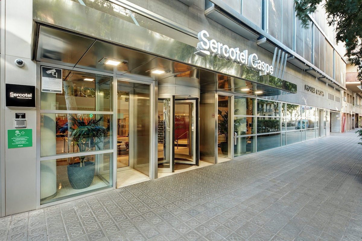 Glassfasaden og inngangspartiet til Sercotel Caspe ved et fortau i Barcelona.