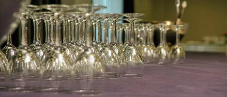 A table with multiple clear glass wine glasses arranged in rows.