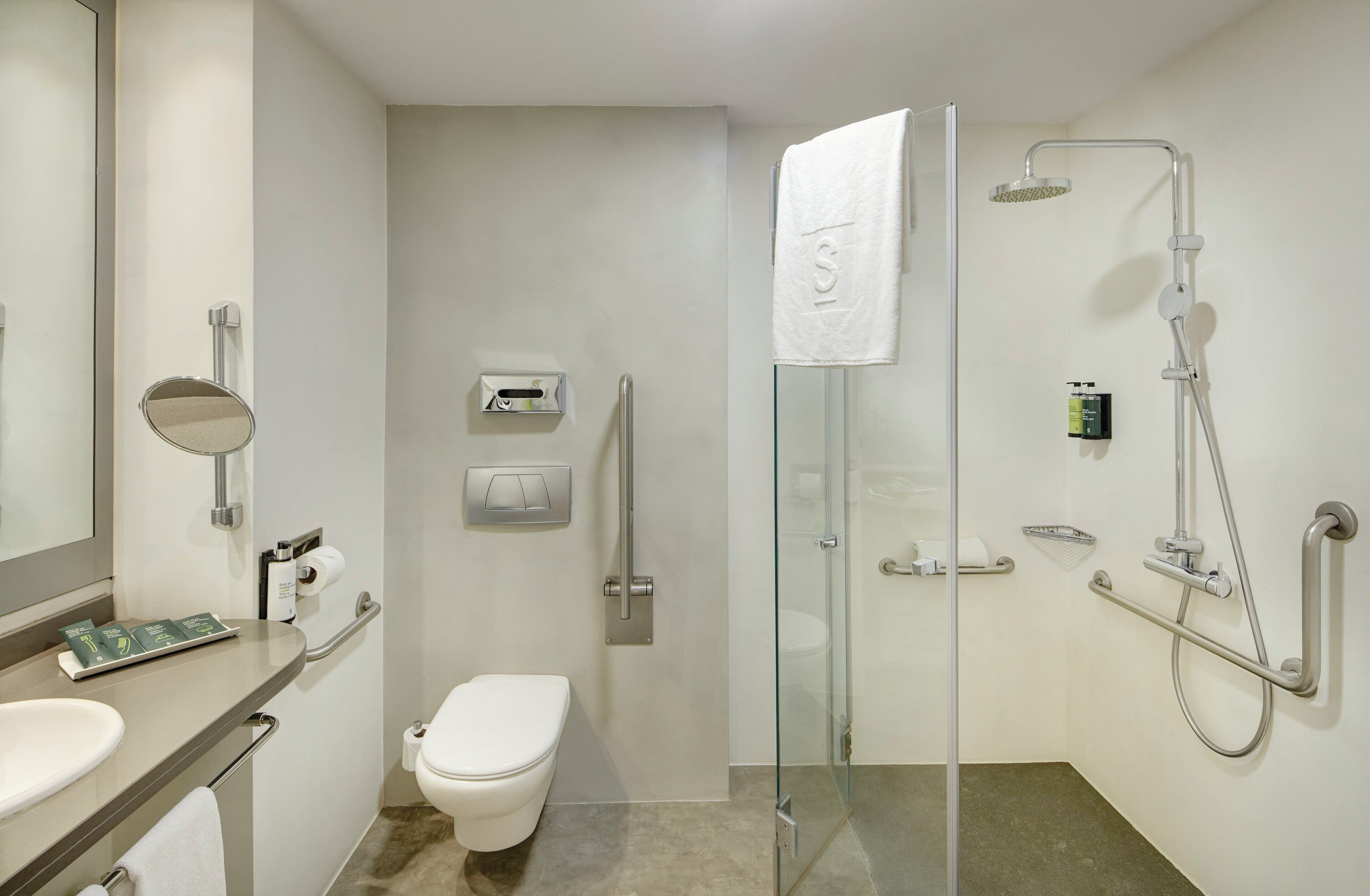Une salle de bain moderne avec une douche à parois de verre, des toilettes, un lavabo et un miroir.