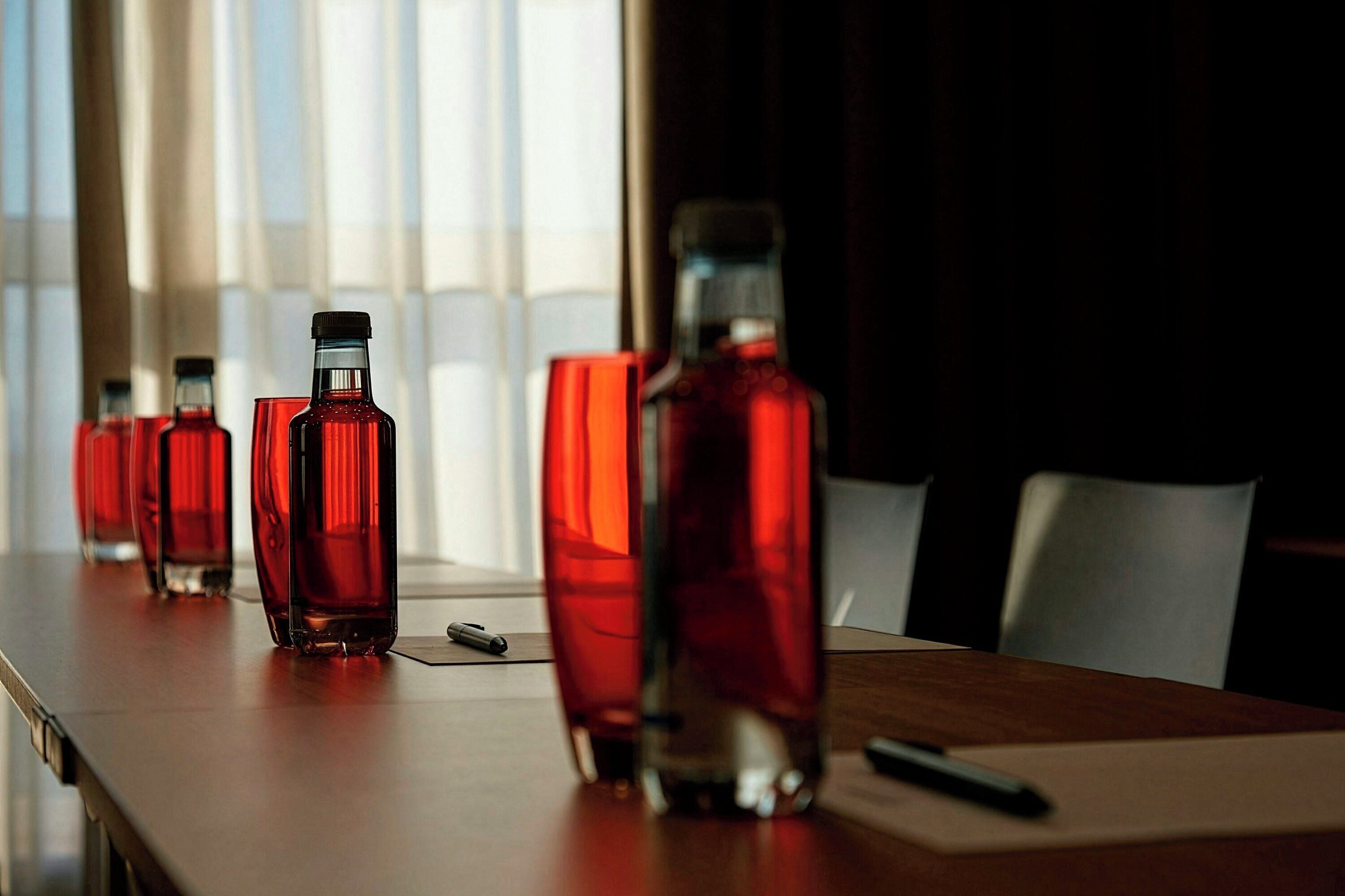 Une table avec plusieurs bouteilles et des verres, un stylo et un bloc-notes.