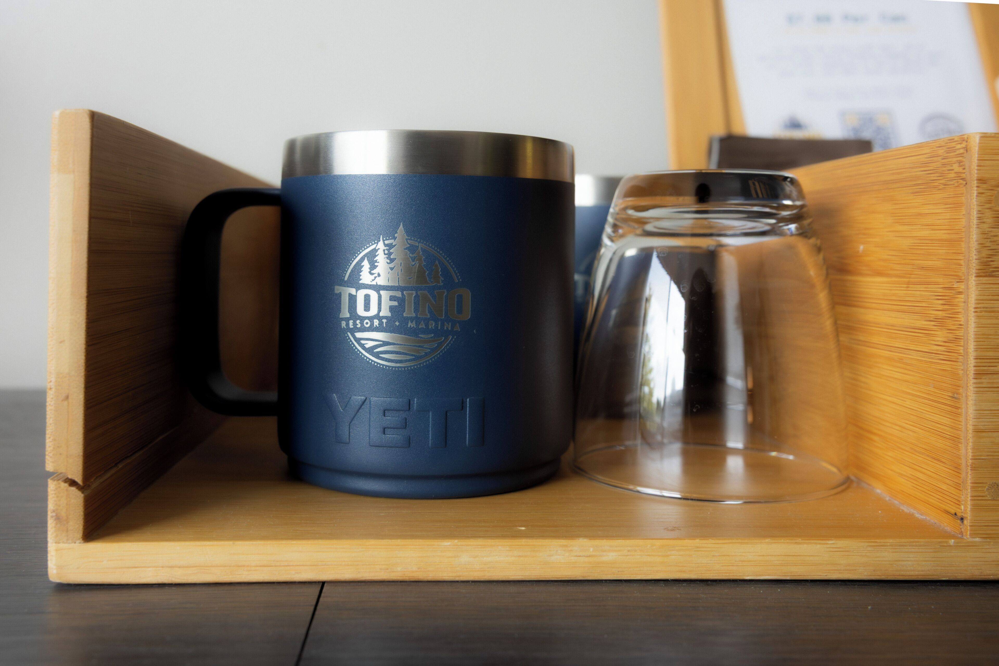 A TOFINO branded mug and a glass on a wooden tray.