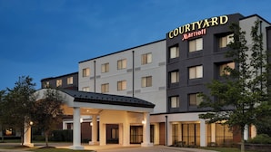 Un hotel Courtyard Marriott dal design moderno, con ingresso coperto e diversi piani.