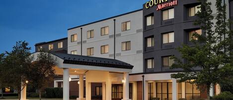 A Courtyard Marriott hotel with a modern design, featuring a covered entrance and multiple floors.