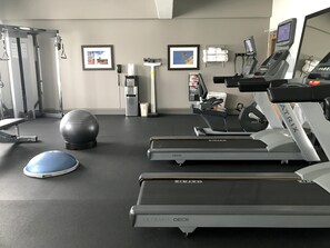 A gym with treadmills, an exercise ball, and a stationary bike.