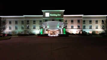 Un hotel Holiday Inn con una entrada destacada, varios pisos y una fachada bien iluminada.