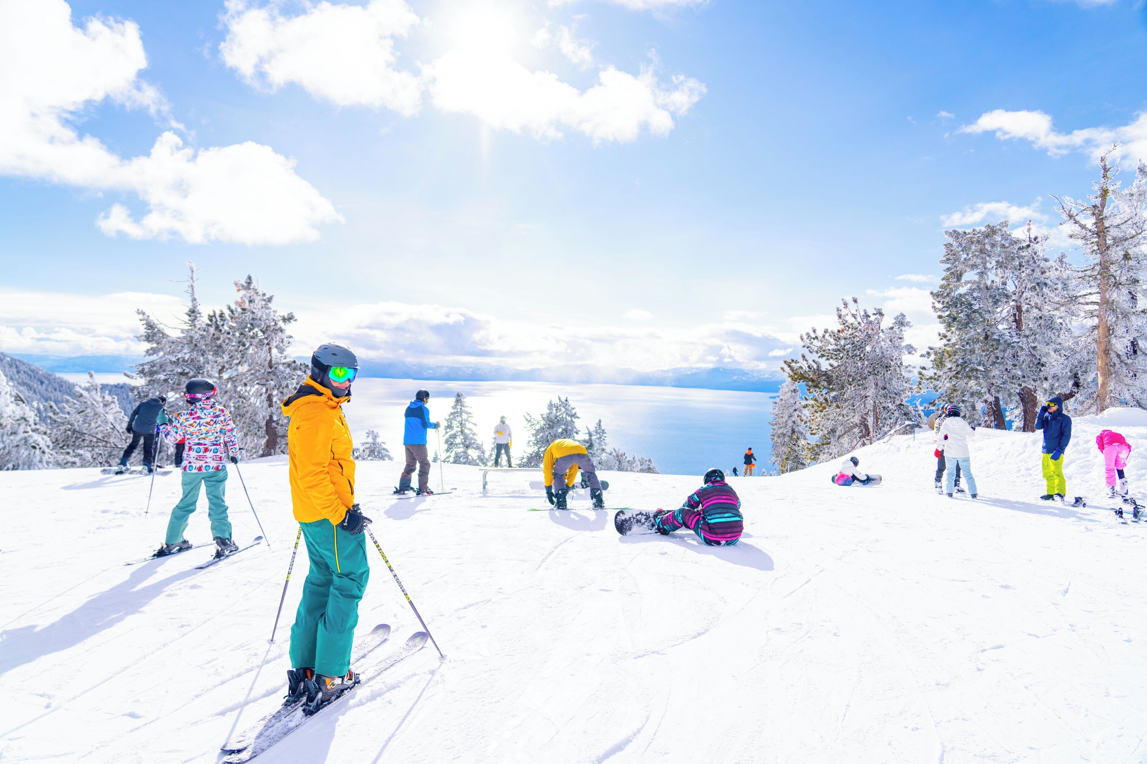 A snowy ski slope with skiers and snowboarders.