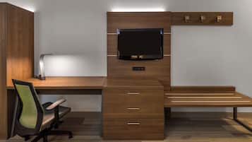 A modern office desk with a flat-screen monitor, drawers, and a chair.
